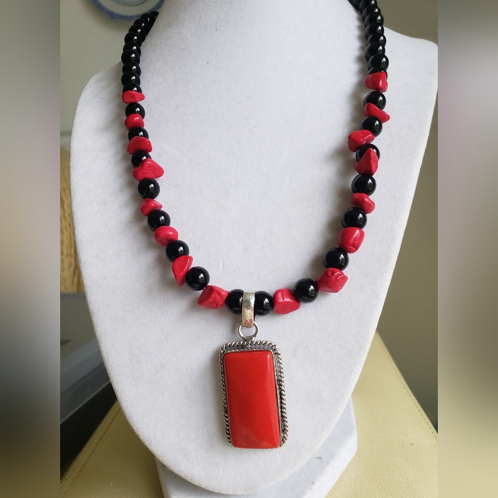 New, handmade necklace with coral pendant set in silver.